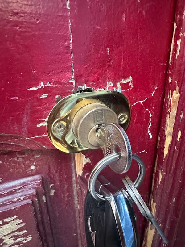 Test d'une clé insérée dans un cylindre de serrure bloqué sur une porte d'entrée.